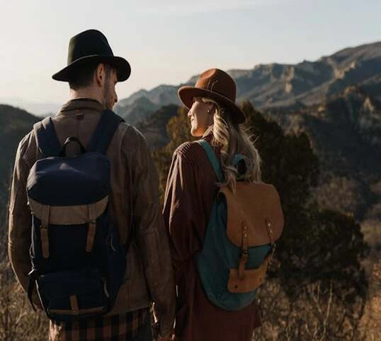 Couple with backpacks, standing, admiring nature.