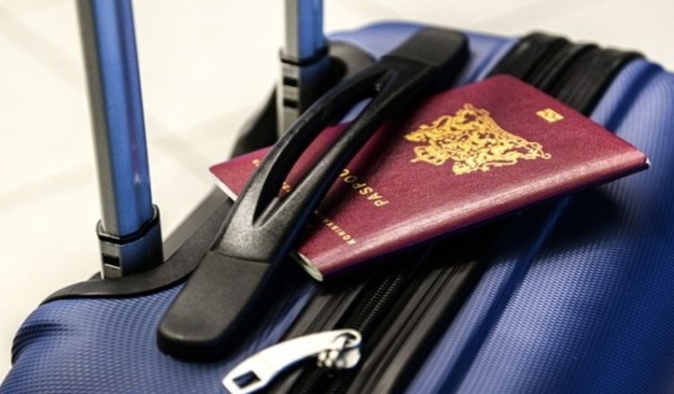 Thailand Tourist visa with a blue travel trolley bag and a passport placed on top.