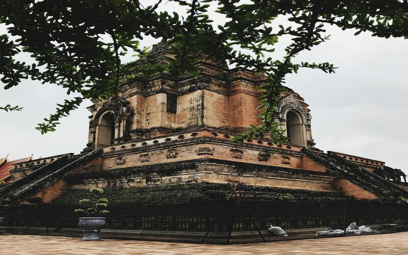 The evening view of Thailand's Wat Chedi Luang is serene, with golden lights and a tranquil atmosphere.